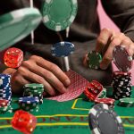 Gambler,Man,Hands,Pushing,Large,Stack,Of,Colored,Poker,Chips